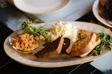 Salmon tartare served with grated butter and roasted bread. Table with food on terrace