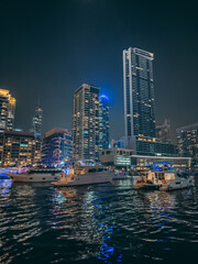 Dubai Marina, harbour, cruise boat and canal promenade view at night, in Dubai, United Arab Emirates