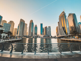 Dubai Marina, harbour, cruise boat and canal promenade view at sunset, in Dubai, United Arab Emirates