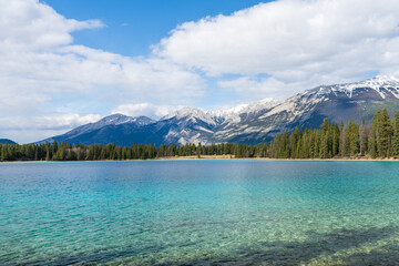 Lake Annette lake shore beach, Pyramid mountain reflection on the lake. Jasper National Park stunning nature scenery in summer time. Landscape of Canadian Rockies, Alberta, Canada.
