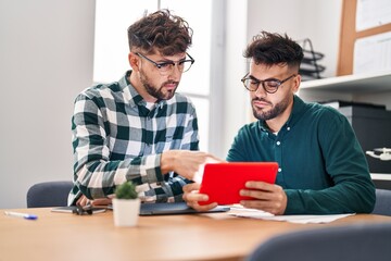 Fototapeta premium Young couple business workers using touchpad working at office