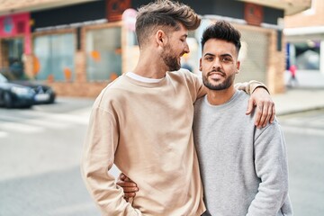 Naklejka premium Young couple smiling confident hugging each other at street