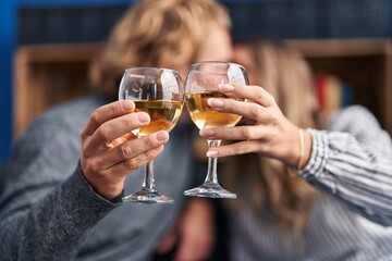 Man and woman couple kissing and toasting with glass of champagne at home