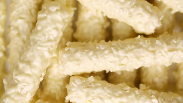 White chocolate candies close-up slowly rotate. Dessert made from coconut flakes, mastic, marshmallows and sugar syrup. Colorful sweet desserts for candy bar and cake decoration.