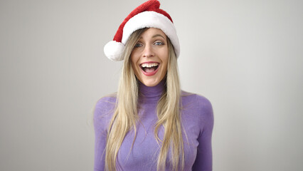 Young blonde woman smiling confident wearing christmas hat over isolated white background