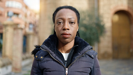 African american woman standing with serious expression at street