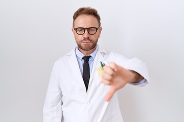 Middle age doctor man with beard wearing white coat looking unhappy and angry showing rejection and negative with thumbs down gesture. bad expression.