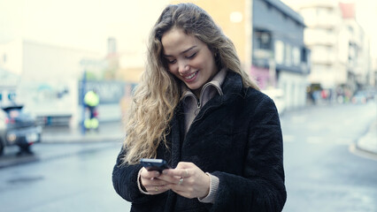 Young beautiful hispanic woman smiling confident using smartphone at street