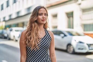 Young beautiful hispanic woman looking to the side with serious expression at street