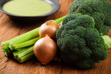 Fresh broccoli, celery and onion close-up. Ingredients for a healthy detox soup on a wooden table