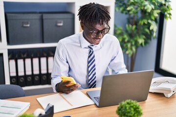 African american man business worker using laptop and smartphone at office