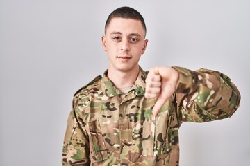 Young man wearing camouflage army uniform looking unhappy and angry showing rejection and negative...