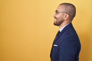 Hispanic man with beard wearing suit and tie looking to side, relax profile pose with natural face...