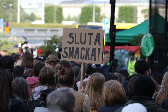 Swedish protester with sign in Swedish: "Stop talking!"