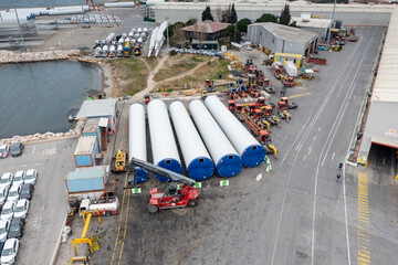 Wind turbines with blades and bodies ready for installation, waiting in port to be transported to wind turbine farms for electricity generation
