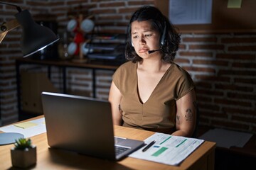 Young hispanic woman working at the office at night depressed and worry for distress, crying angry and afraid. sad expression.