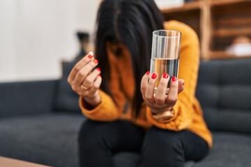 Young latin woman patient holding mental pill treatment at clinic
