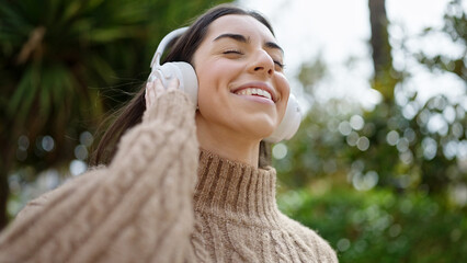 Young beautiful hispanic woman smiling confident listening to music at park © Krakenimages.com