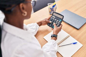 African american woman business worker using calculator at office
