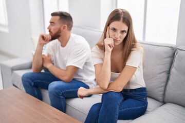 Fototapeta na wymiar Man and woman stressed for argument sitting on sofa at home