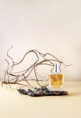 Perfume in a spray bottle and tree bark with lichens on a beige background