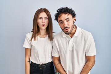 Fototapeta premium Young couple wearing casual clothes standing together afraid and shocked with surprise and amazed expression, fear and excited face.