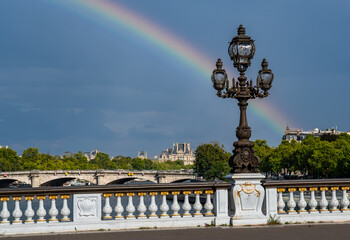 Fototapeta na wymiar Bridge Pont Alexandre III Over River Seine With Colorful Rainbow in Paris, France