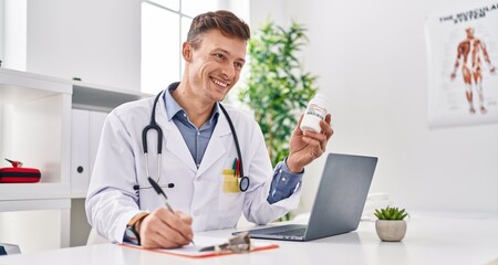 Young man doctor prescribing pills treatment writing on document at clinic