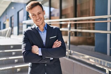 Young man business worker smiling confident standing with arms crossed gesture at street © Krakenimages.com