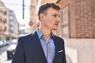 Fototapeta premium Young man business worker standing with relaxed expression at street