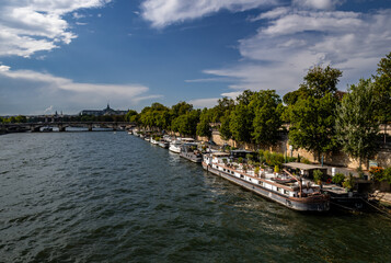 River Seine In Paris, France With Promenade And Anchored Houseboats