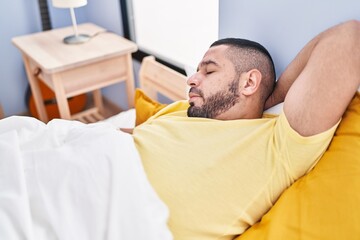 Obraz premium Young latin man lying on bed sleeping at bedroom
