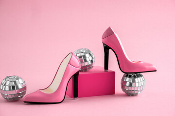 High heel shoes with disco balls on pink background.