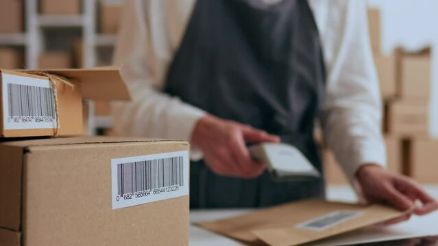 Business owner, Transport company worker In process gluing barcode on a cardboard box in an e-commerce room In slow motion Professional worker managing business industrial revolution, delivery service