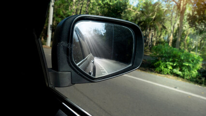 Obraz premium Car on the road drive to nature,Travel to clear the province, Beside with green of nature speed, Focus to mirror view backside.