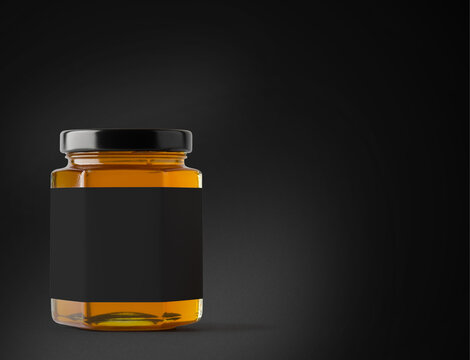 Jar of honey with label on a black background.
