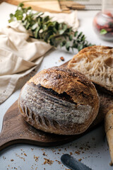 Artisan Batard Sourdough healthy Bread with leaf scoring. Open crumb high hydration Sourdough bread set on white table.