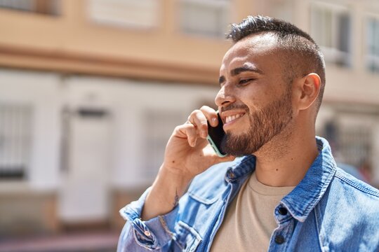 Young hispanic man smiling confident talking on the smartphone at street