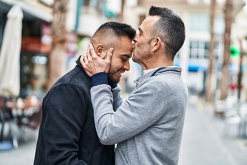 Two men couple hugging each other kissing at coffee shop terrace