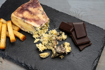 Cheese collection, blue stilton English cheese matured in red porto wine served as dessert with walnuts and chocolate