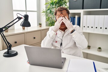 Senior doctor man working on online appointment rubbing eyes for fatigue and headache, sleepy and...