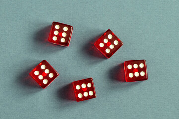 Random number generator. Five red dice with numerical values lie in a chaotic order.