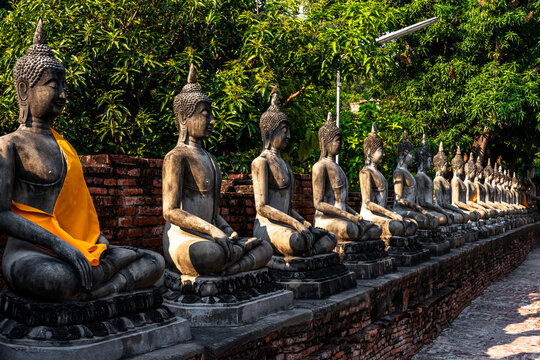 Row of ancient Buddha images in Ayutthaya Historical Park, most historic tourist attraction in Thailand 
