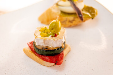Board with typical snack of Basque Country, pinchos or pinxtos skewers with small pieces of bread,...