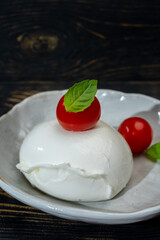Сheese collection, one big ball on soft white italian mozzarella bufala cheese with red tomato and green basil leaves