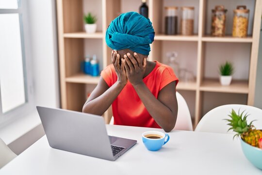 Young African American Woman Worried Using Laptop Drinking Coffee At Home