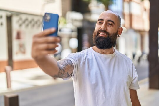 Young bald man smiling confident making selfie by the smartphone at street