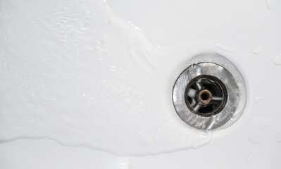 Water drain down. Flow away on bathtub. Top view of drainage hole. Household plumbing. Cleaning and hygiene concept.