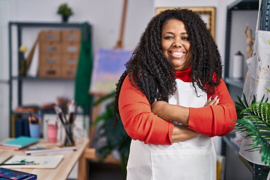 African american woman artist smiling confident standing with arms crossed gesture at art studio