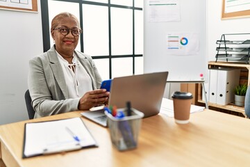 Senior african american woman business worker using smartphone working at office